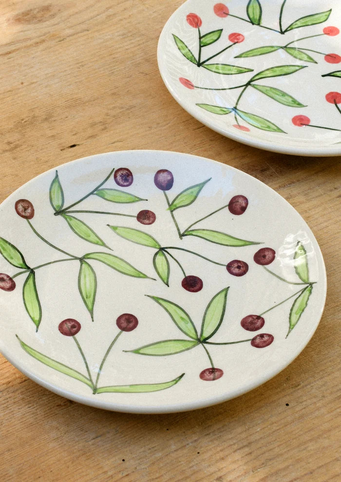 Ceramic plates with illustrated cherries.