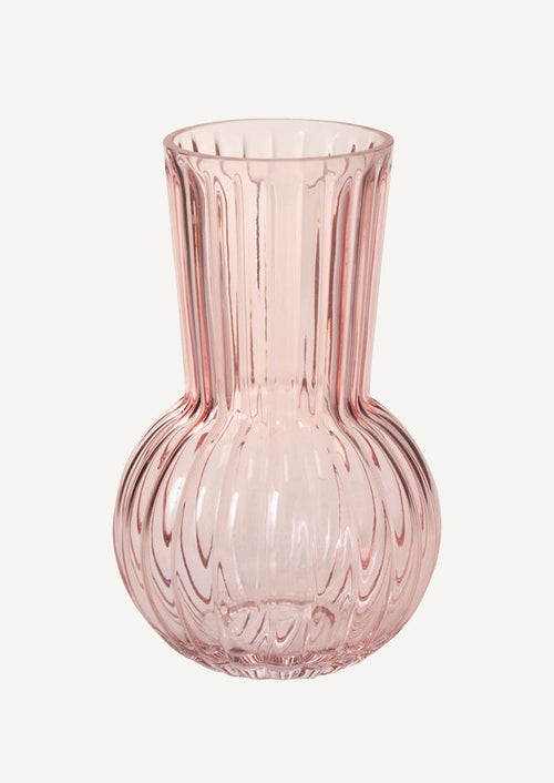 A glass vase in fluted light pink glass with bulb-like shape.