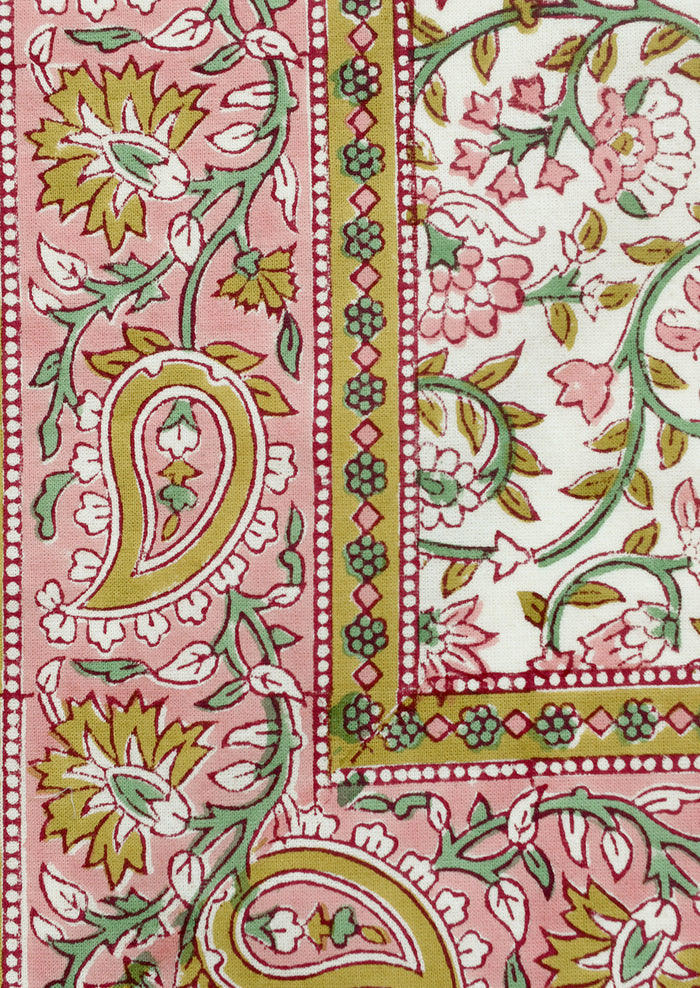 A set of cloth napkins in pink and mustard paisley print.