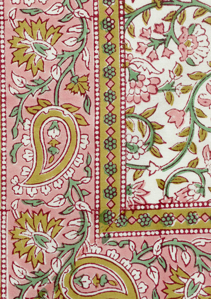 A set of cloth napkins in pink and mustard paisley print.