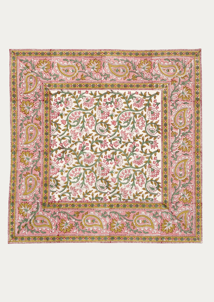 A set of cloth napkins in pink and mustard paisley print.