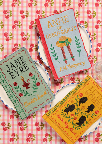 Four napkins resembling book covers of 'Wuthering Heights', 'Jane Eyre', 'Anne of Green Gables', and 'Little Women'.