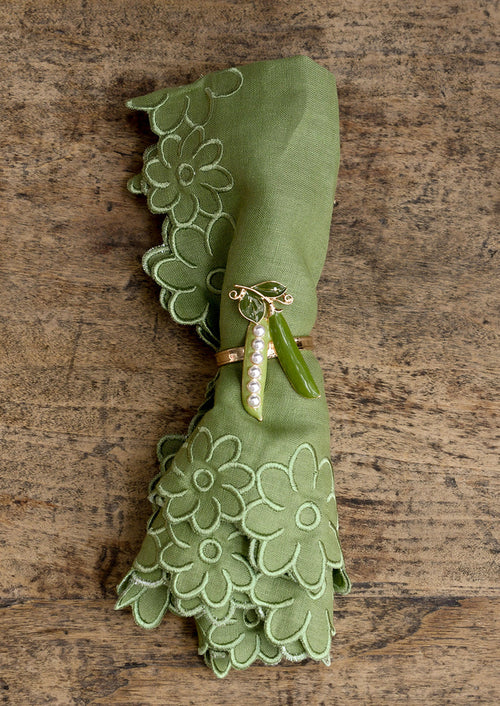 Green napkin with decorative ring on a wooden surface