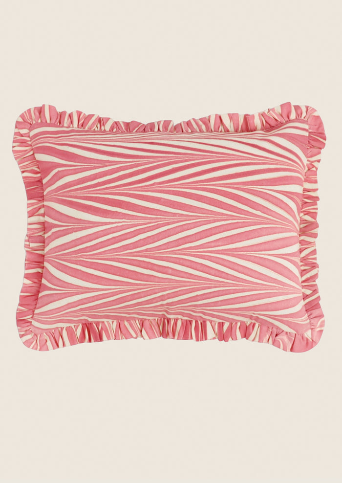 Pink and white striped pillow with ruffled edge on a beige background