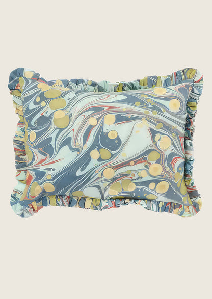 Marbled patterned pillow with ruffled edges on a light background
