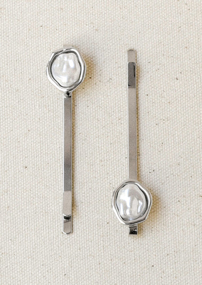 A set of 2 silver hair pins with a faux freshwater pearl on the end of each.
