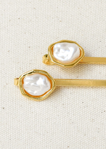 A set of 2 gold hair pins with a faux freshwater pearl on the end of each.