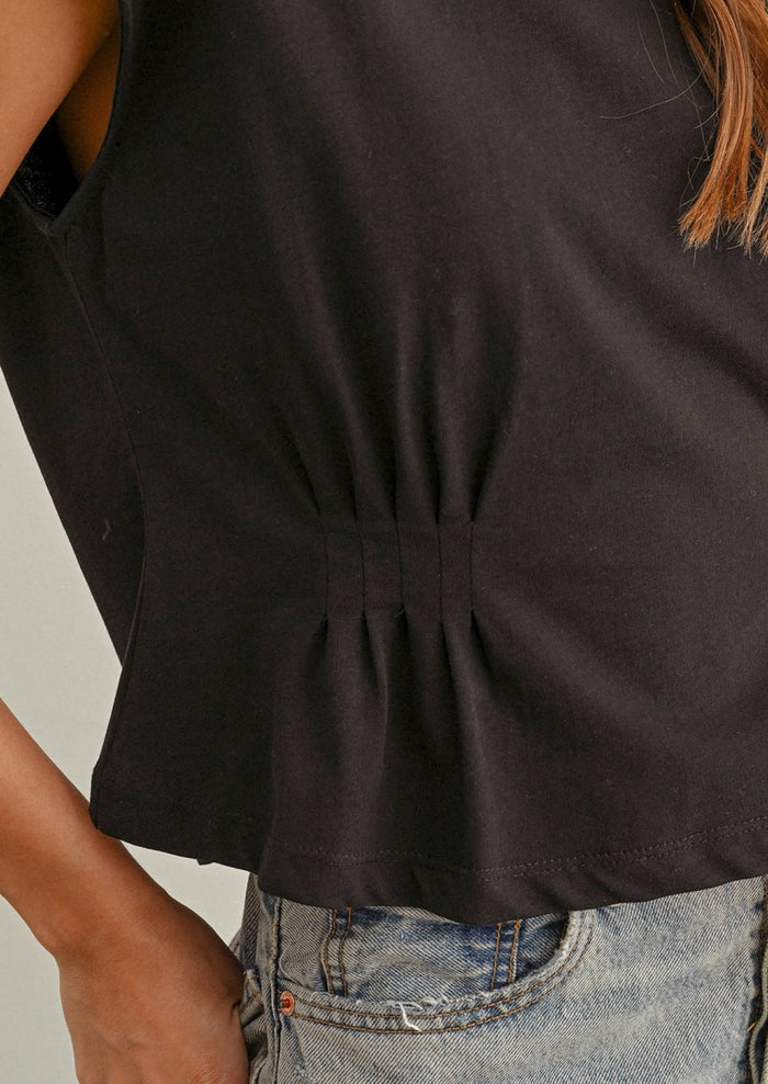 Black sleeveless top worn by a person with a neutral background
