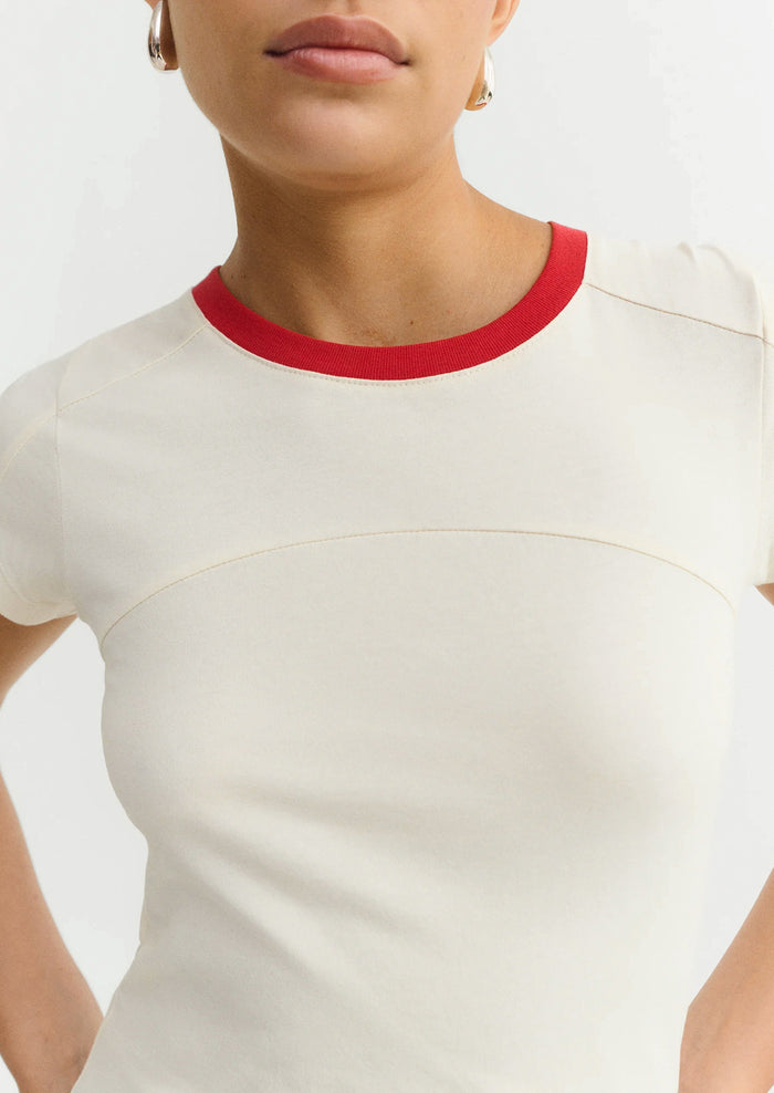 White top with red neckline on a plain background