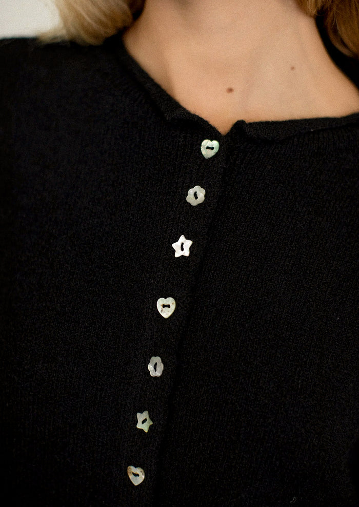 Black shirt with decorative buttons worn by a person