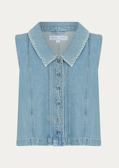 A sleeveless button front top with pointed collar, in light wash denim.