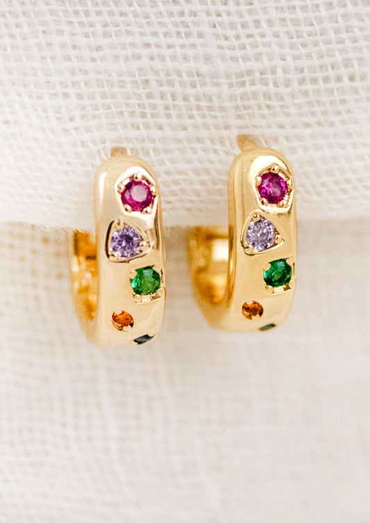 A pair of gold hoops adorned with colorful gems.
