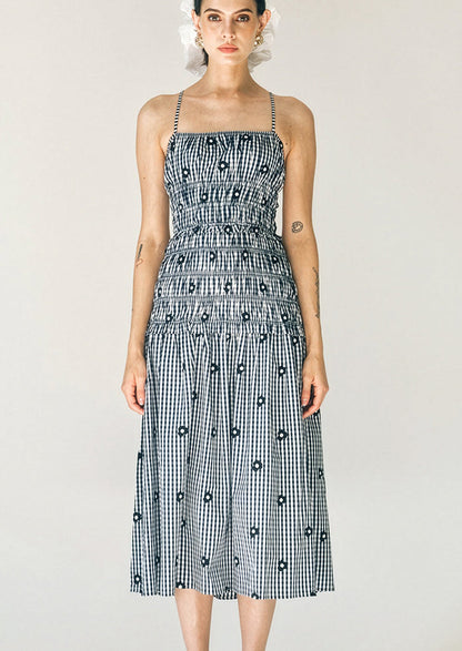 Woman wearing a black and white checkered dress with a plain background